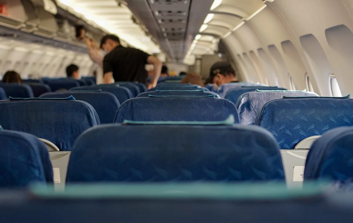 Interior de un avión de la aerolínea Delta con pasajeros abordando