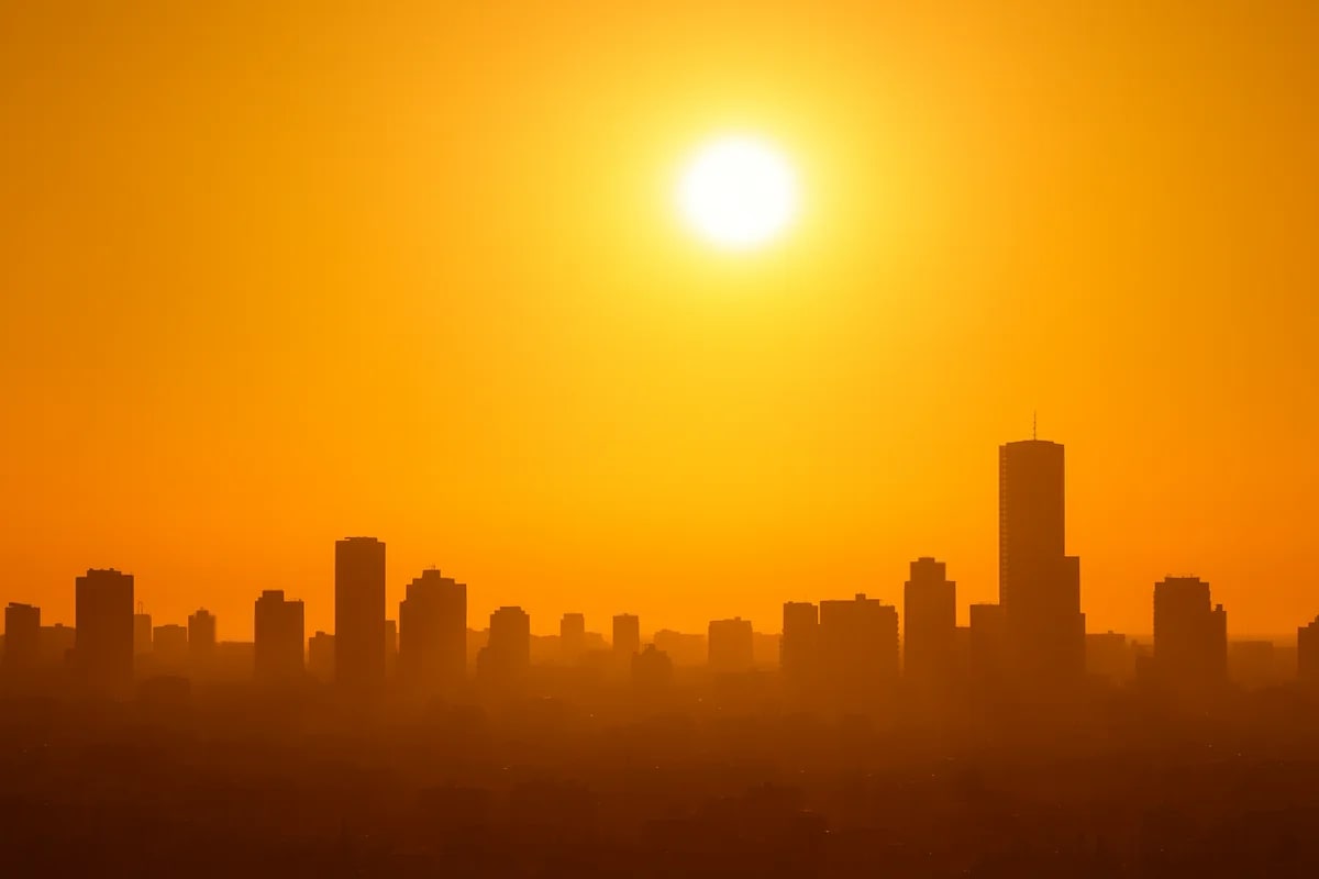 Ciudad bajo una ola de calor con un sol intenso al atardecer