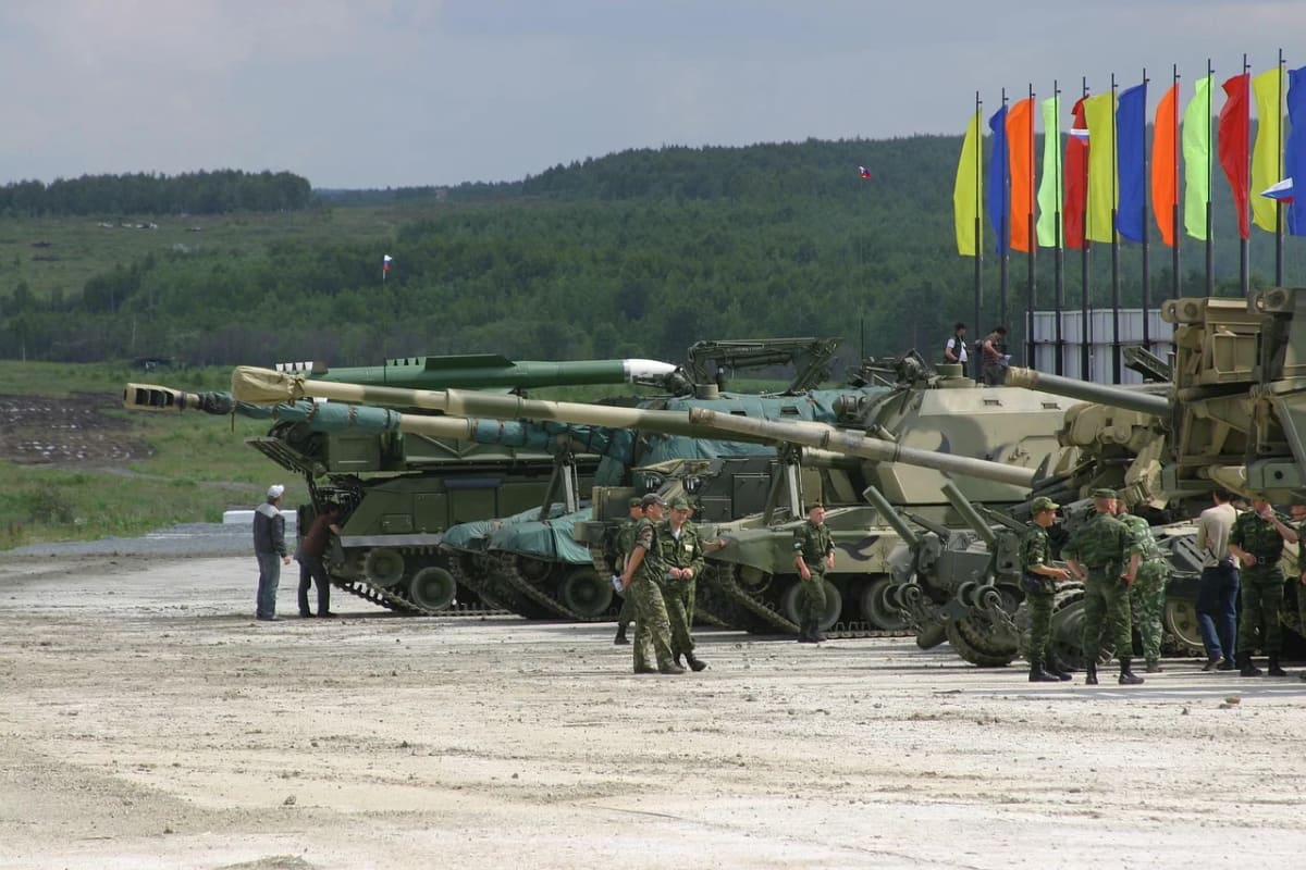 Vehículos militares y soldados rusos en una exhibición con banderas al fondo