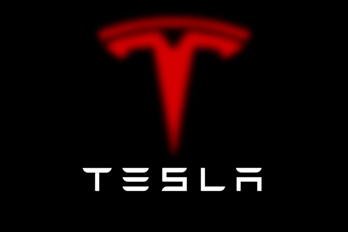 Logo de Tesla en rojo difuminado sobre fondo negro con la palabra TESLA en blanco al frente