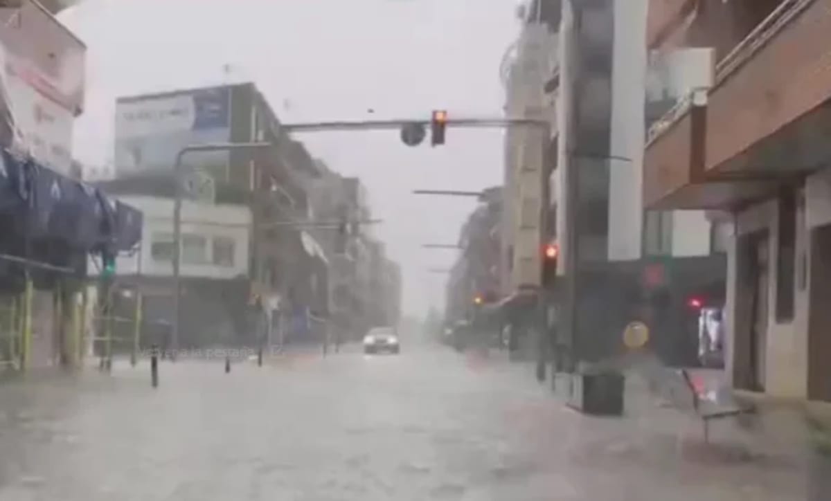 Calle inundada en Catalunya tras lluvias intensas con tráfico interrumpido y semáforos encendidos