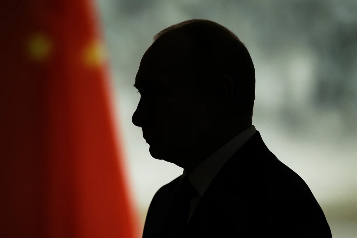 Silueta en negro de Vladímir Putin en primer plano, con un fondo borroso en tonos rojos y grises que evocan una atmósfera tensa y diplomática