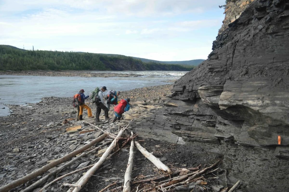 Geólogos analizando los estratos silúricos de la Formación Tetlit en el río Peel, Yukón, durante una expedición en 2015