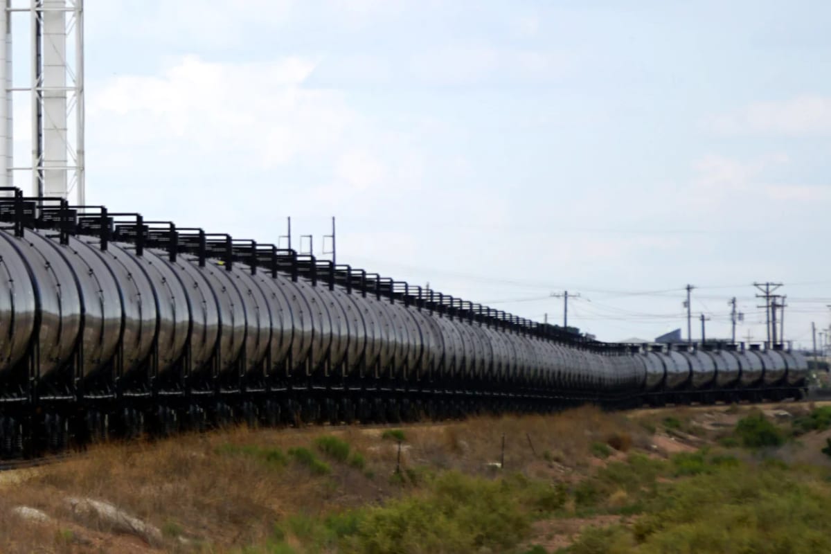 Fila de vagones cisterna de tren para transporte de combustible a lo largo de la vía