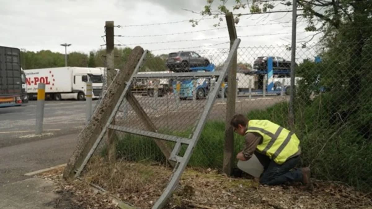 Investigador coloca una trampa para mosquitos junto a una valla metálica en zona de transporte