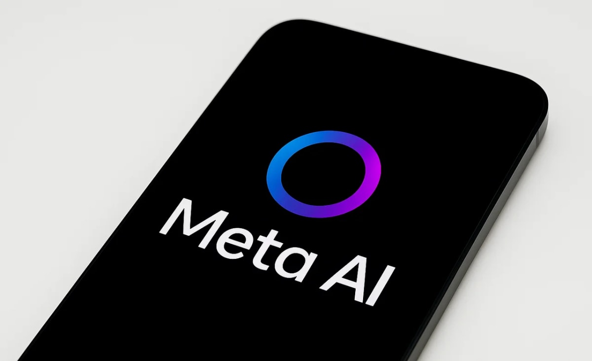 Teléfono móvil inclinado sobre fondo blanco opaco con el logotipo y texto de Meta AI en la pantalla negra