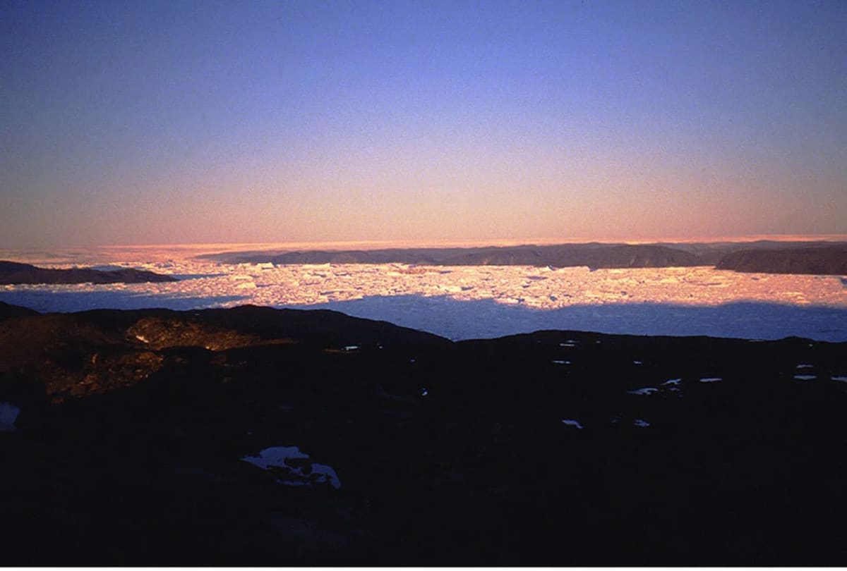 Vista nocturna de la capa de hielo de Groenlandia y el fiordo de Ilulissat con icebergs en primer plano