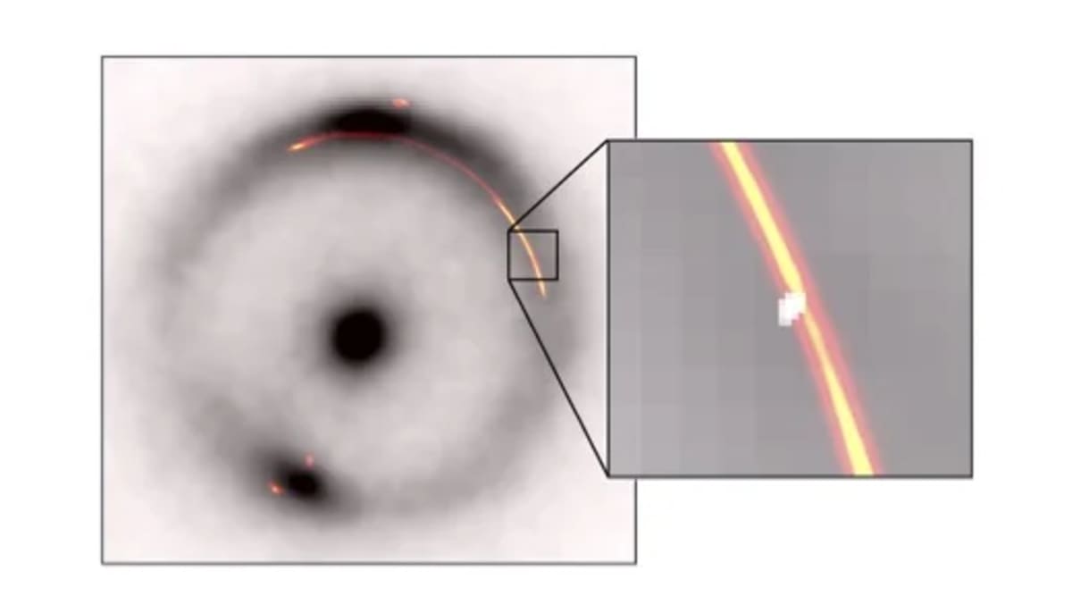 Galaxia distante distorsionada por una lente gravitacional con un anillo negro y una segunda lente más pequeña