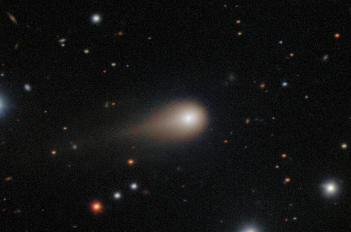 Cometa interestelar 3I/ATLAS con coma brillante y cola extendida sobre fondo estrellado