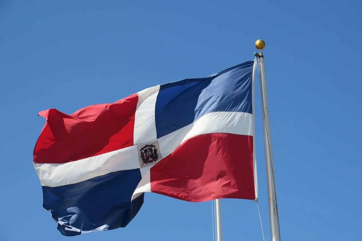 Bandera de la República Dominicana ondeando sobre un cielo despejado