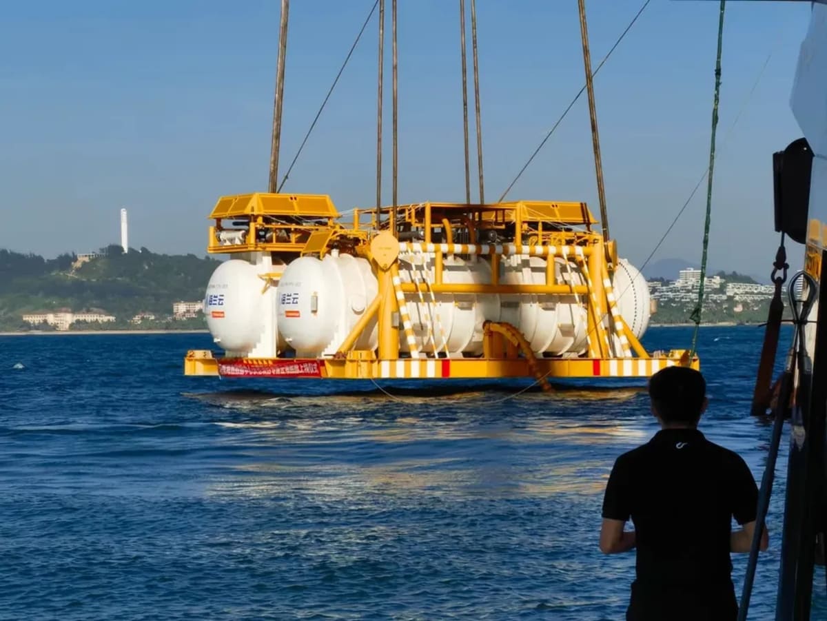 Módulos cilíndricos de un centro de datos submarino siendo bajados al mar frente a Hainan