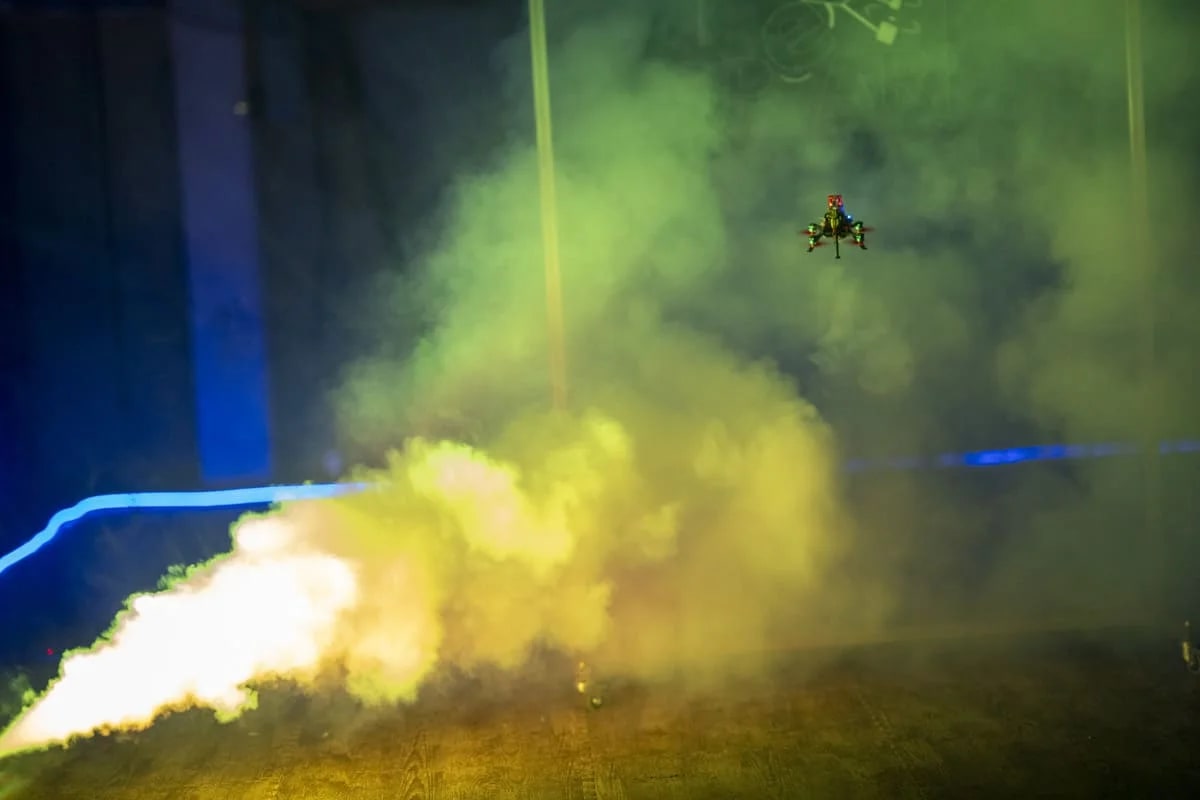 Un diminuto robot aéreo de rescate volando en un entorno con poca luz y humo, diseñado para operar en espacios reducidos