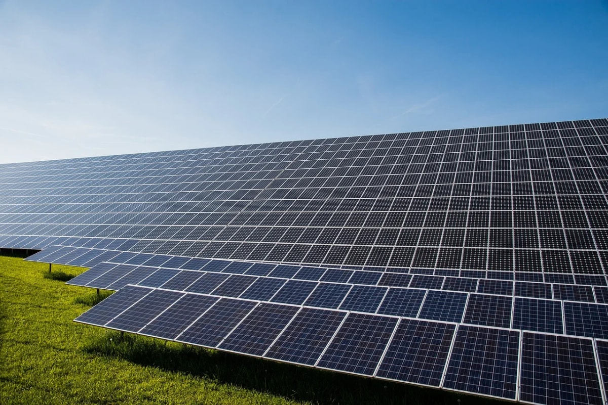 Paneles solares fotovoltaicos instalados sobre un campo verde, orientados hacia el cielo despejado para captar la luz del sol