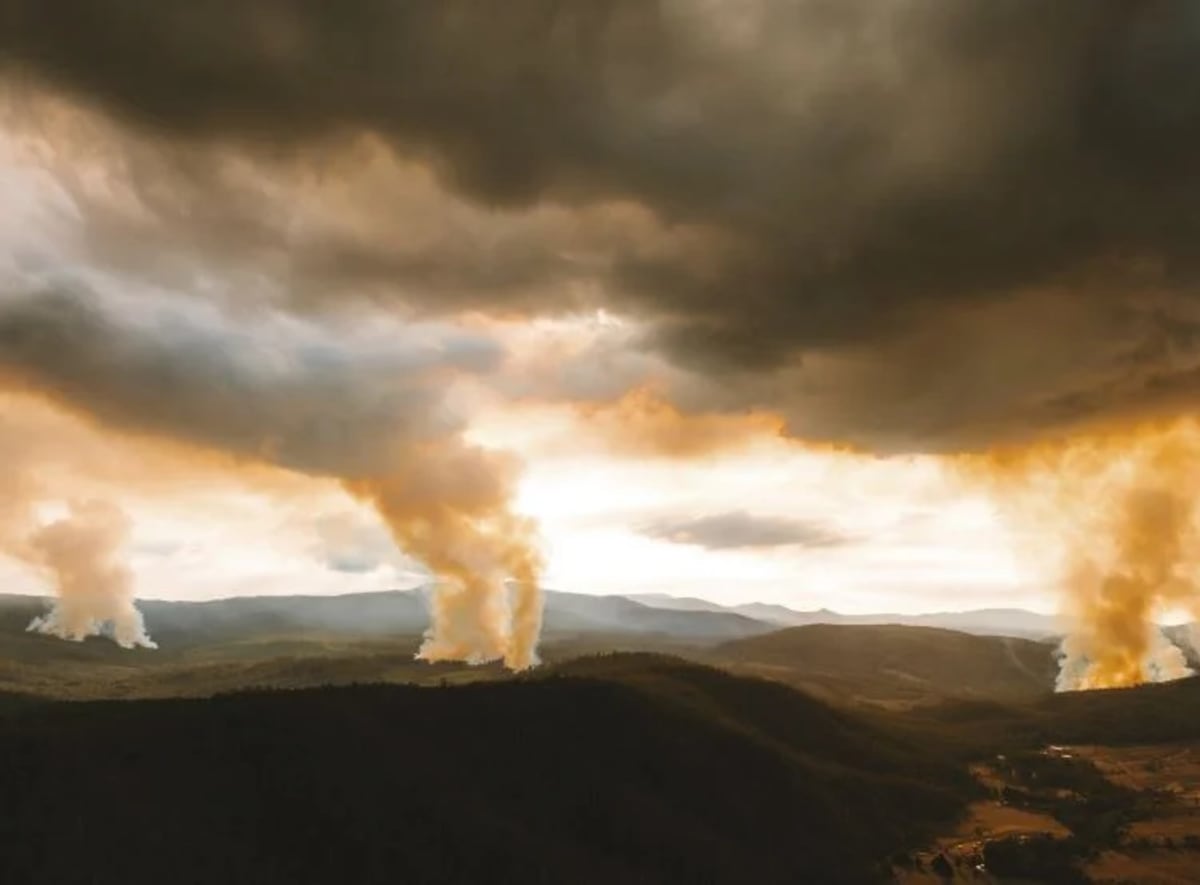 Fuego y humo sobre una zona boscosa en Tasmania tras la quema de restos de tala