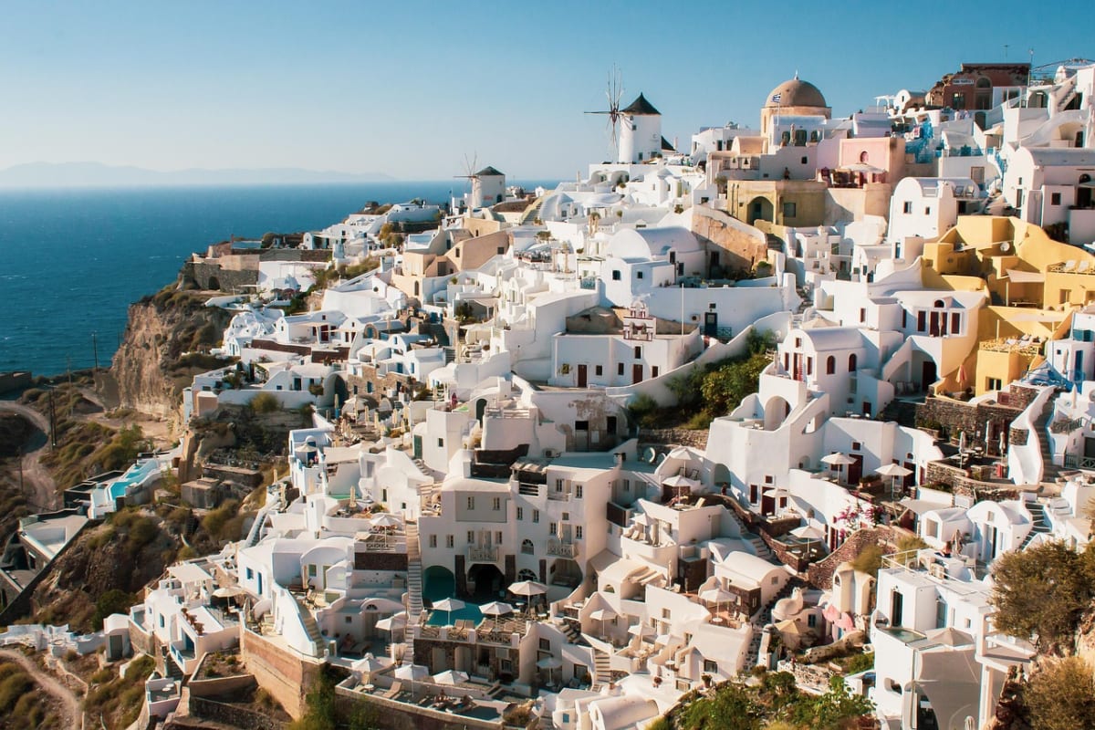Vista panorámica de Santorini con sus casas blancas en terrazas sobre el acantilado, frente al mar Egeo