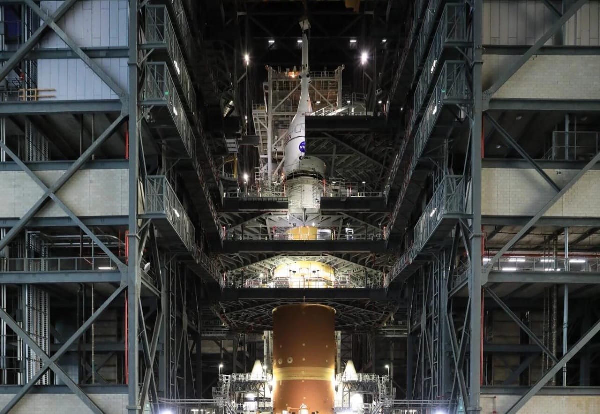 Técnicos levantan la nave Orión con una grúa para colocarla sobre el cohete SLS dentro del Edificio de Ensamblaje de Vehículos de la NASA