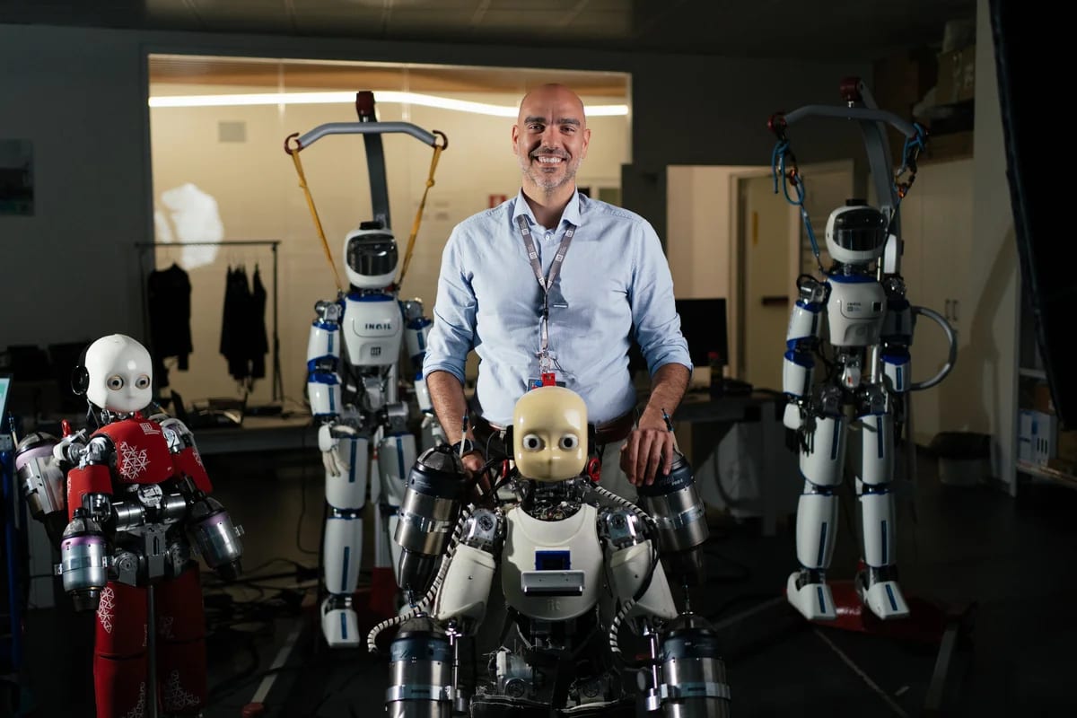 Daniele Pucci posando con robots humanoides del Instituto Italiano de Tecnología