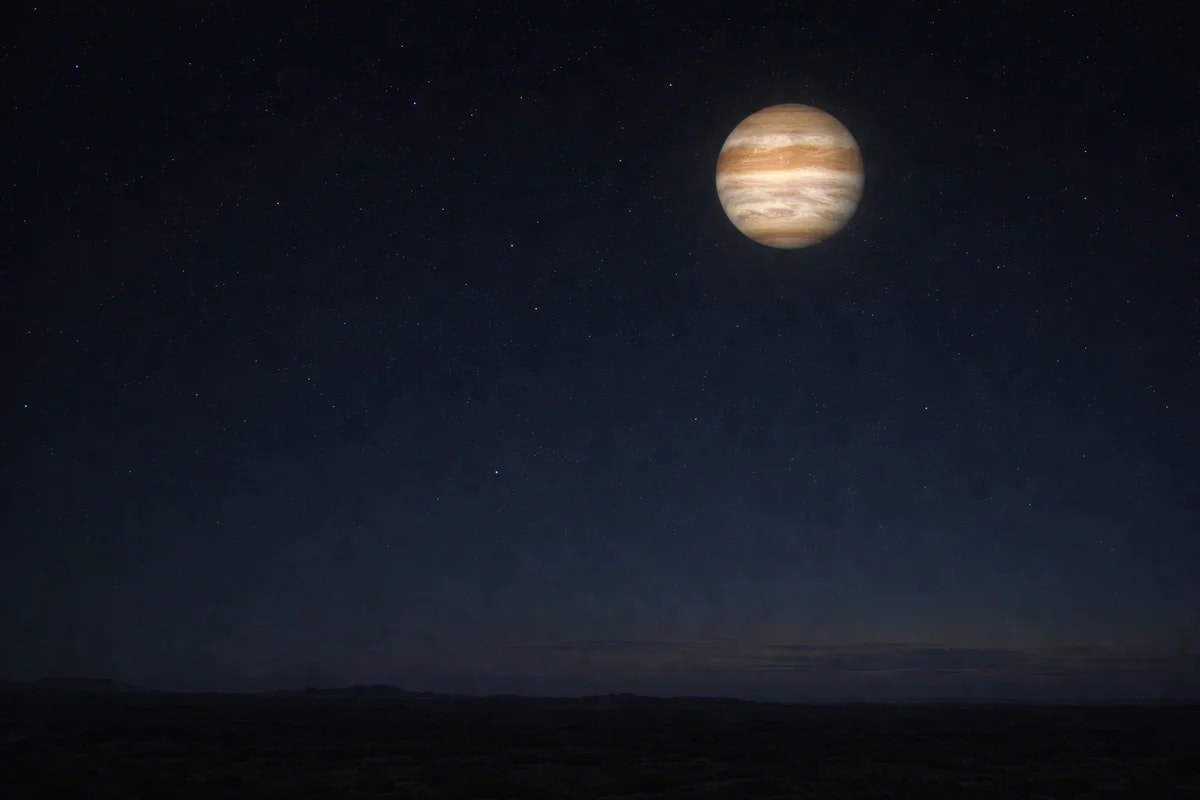 Júpiter brillante en el cielo nocturno sobre un horizonte oscuro y silencioso