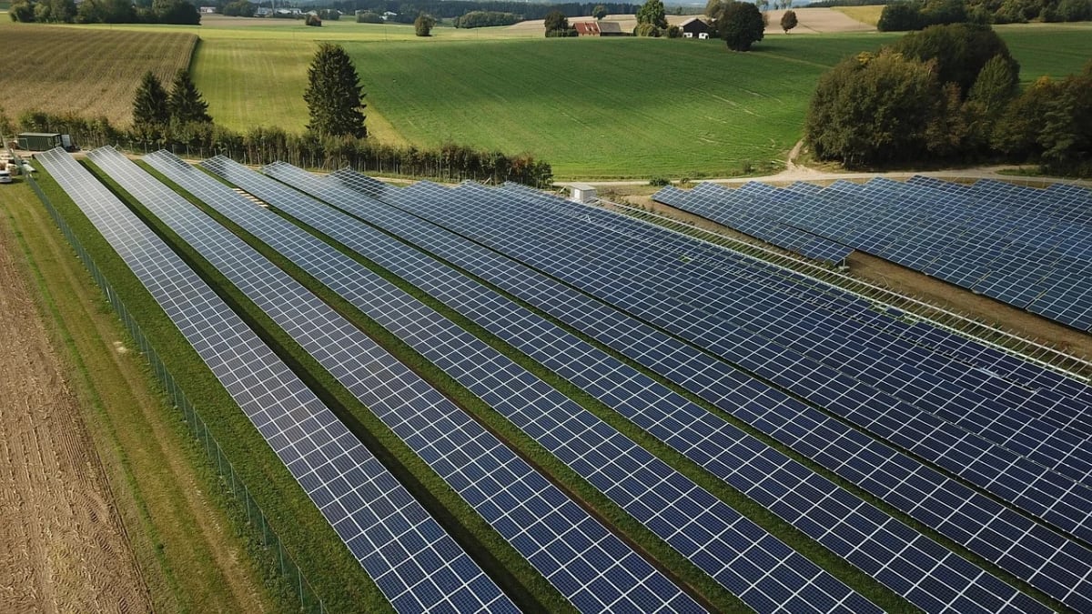 Planta solar fotovoltaica con filas de paneles instalada en una zona rural