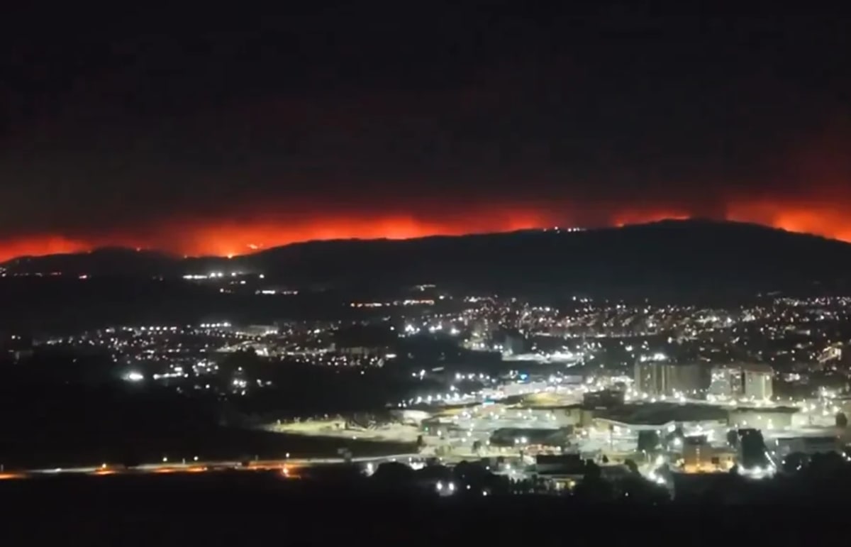 Incendios forestales activos en colinas cercanas a una ciudad del sur de Chile