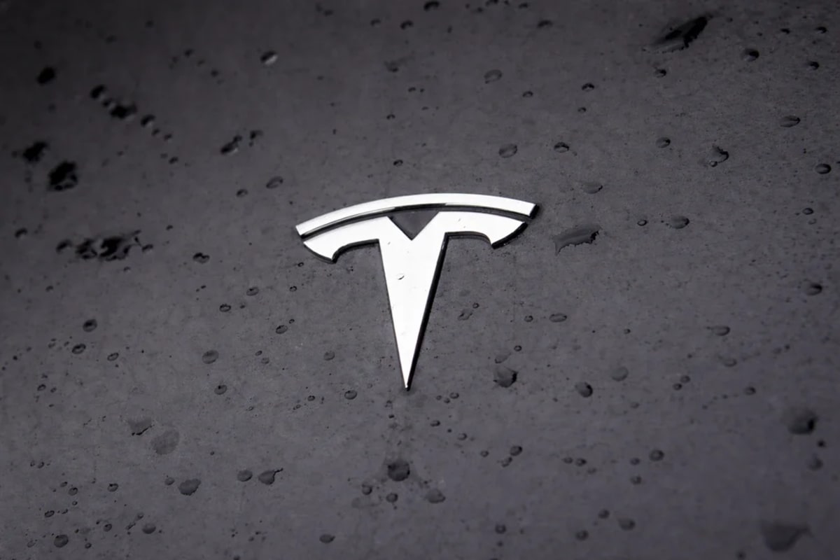 Logo de Tesla sobre carrocería mojada
