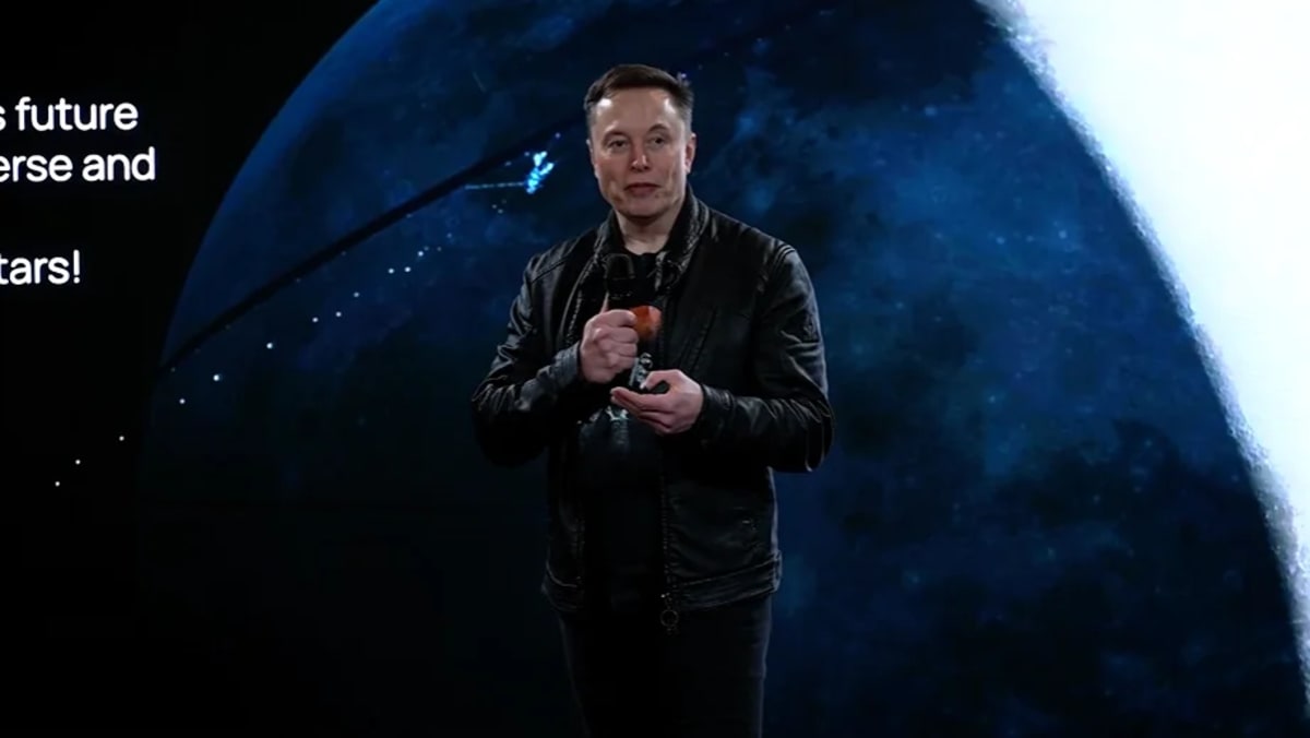 Elon Musk durante una presentación de xAI con una imagen del espacio proyectada al fondo