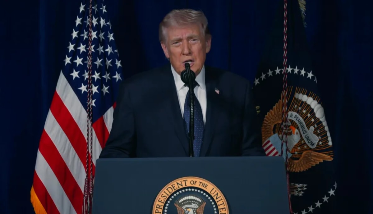 Donald Trump ofrece un discurso desde un podio presidencial con banderas de Estados Unidos al fondo