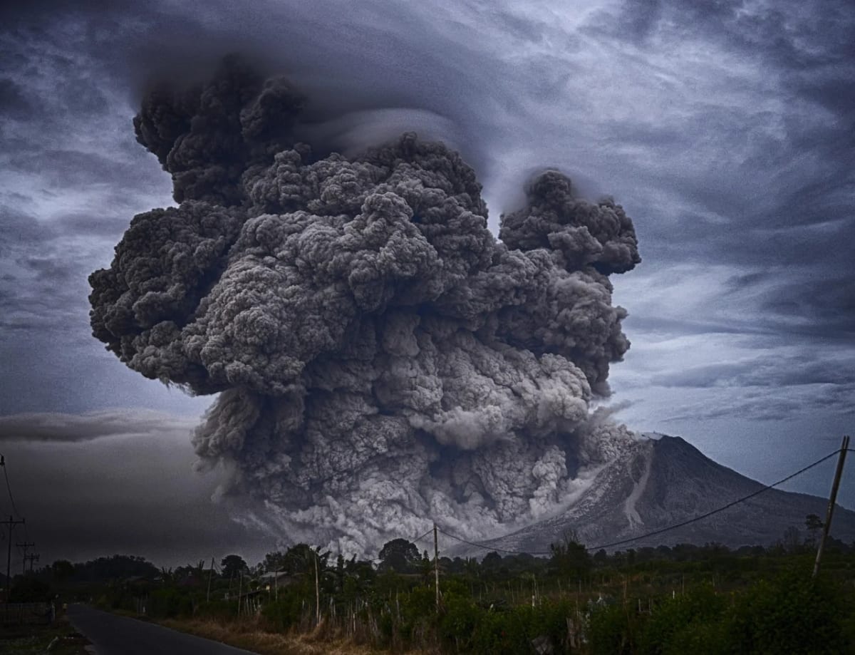 Erupción volcánica con gran columna de ceniza elevándose sobre el paisaje. Imagen ilustrativa. Créditos: Pixabay.