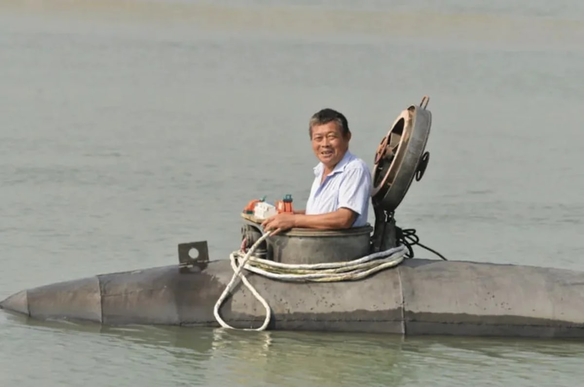 Hombre probando un submarino casero eléctrico en un río