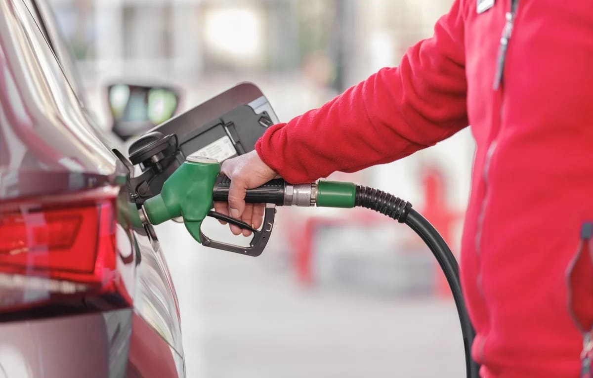 Persona repostando combustible en una gasolinera