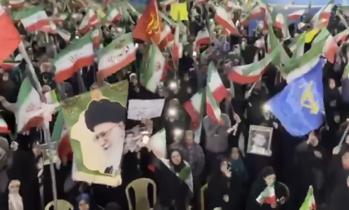 Manifestación con banderas iraníes y retratos de líderes religiosos en apoyo al régimen iraní