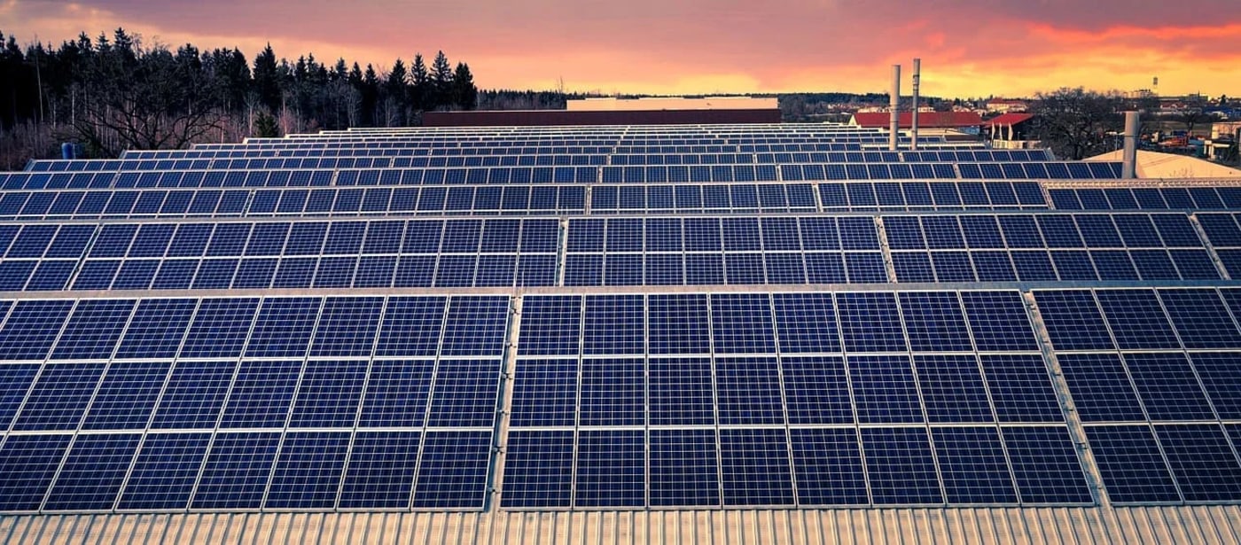 Paneles solares en una instalación fotovoltaica al atardecer, destacando la integración de tecnologías avanzadas para optimizar la producción energética.
