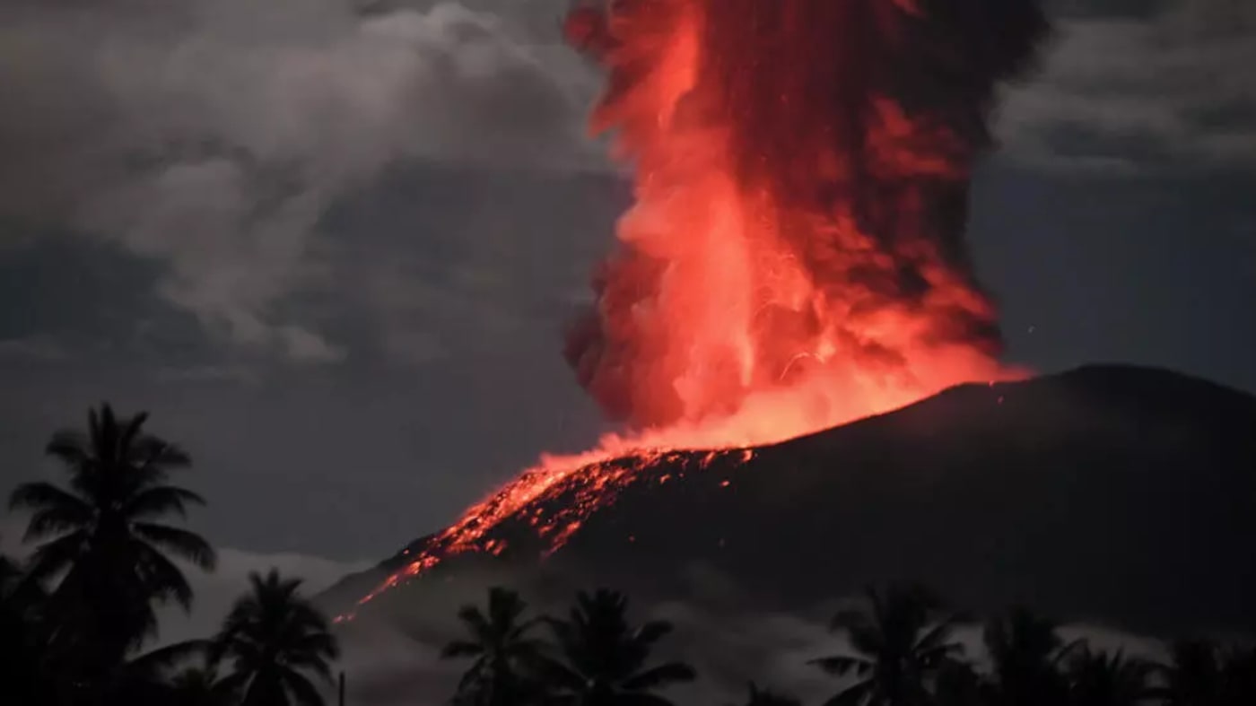 Una erupción del monte Ibu en Indonesia, con una gran columna de ceniza gris elevándose al cielo.