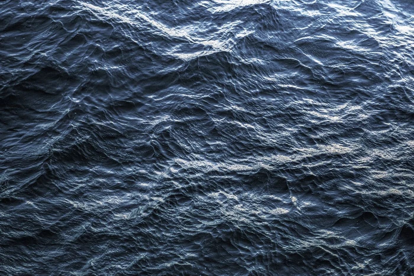 Imagen del océano, capturada desde una vista aérea que muestra la textura profunda y oscura de sus aguas, representando el vasto e inexplorado mundo submarino.