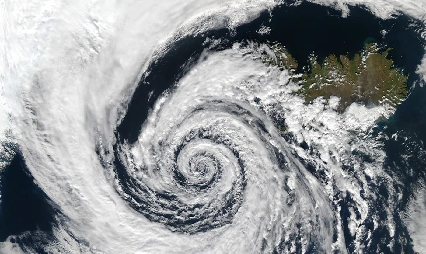 Imagen satelital de una depresión atmosférica cerca de Islandia, con un patrón de nubes en espiral sobre el océano.