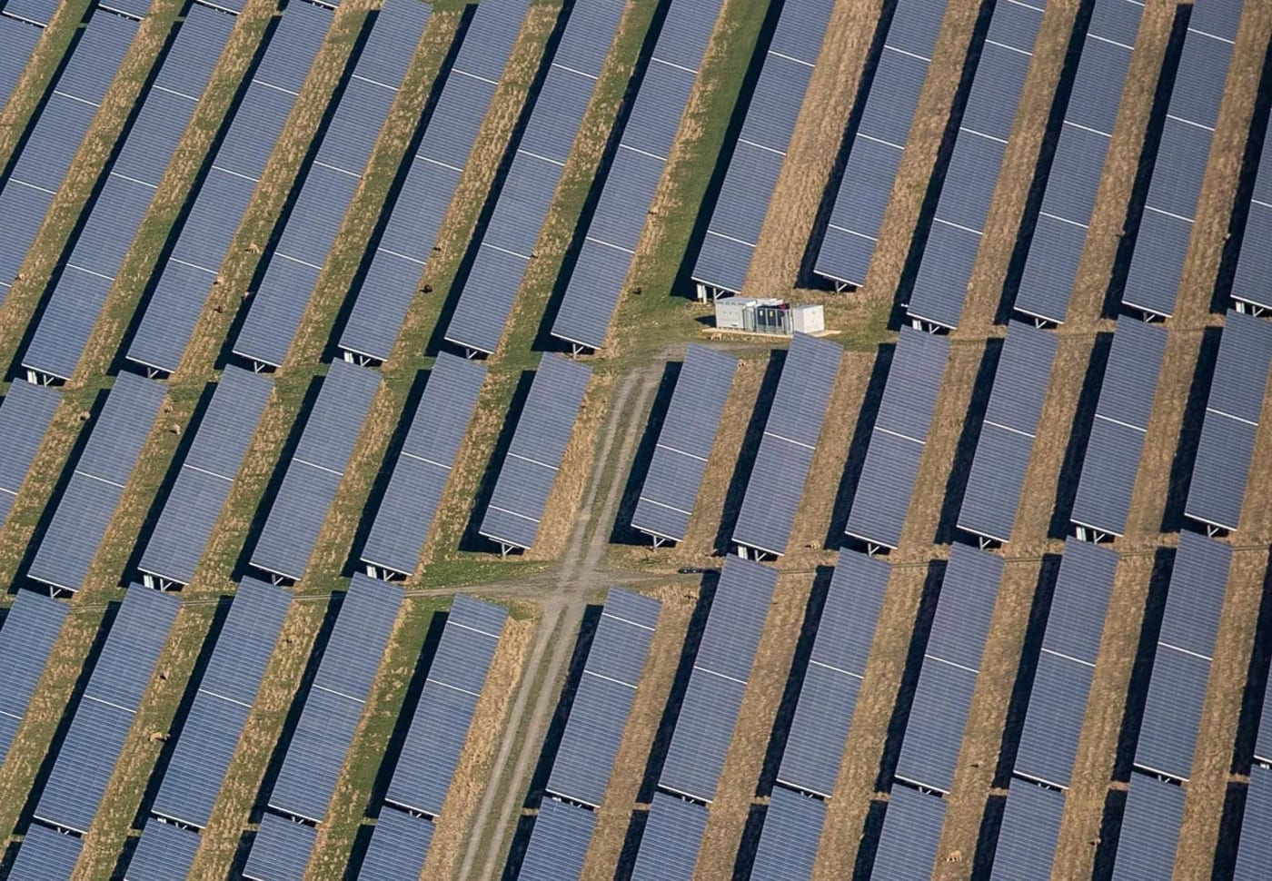 Vista aérea de una microrred solar con múltiples paneles fotovoltaicos alineados en un campo agrícola