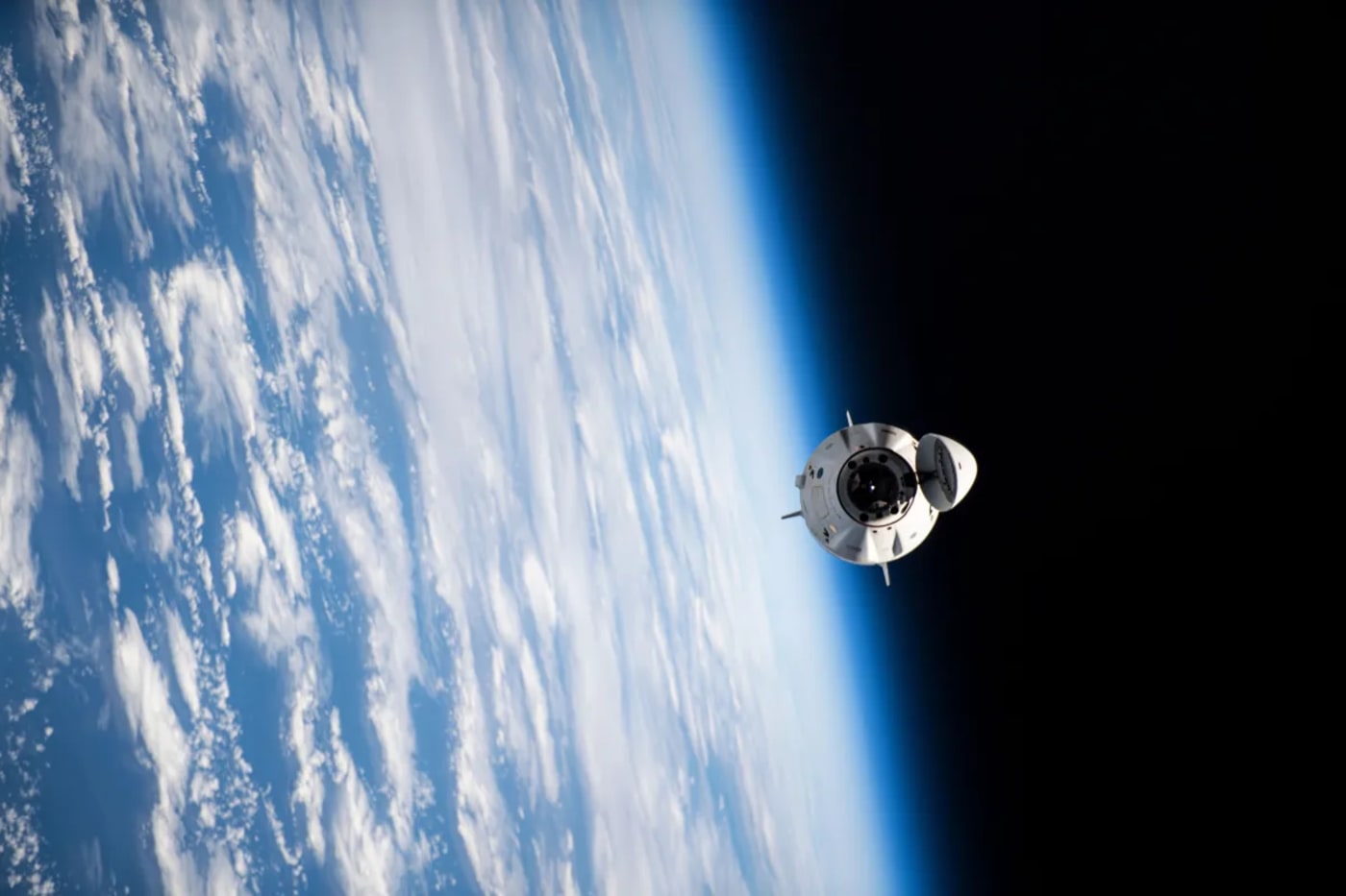 Nave espacial Dragon CRS-32 acercándose a la estación espacial internacional sobre la atmósfera terrestre
