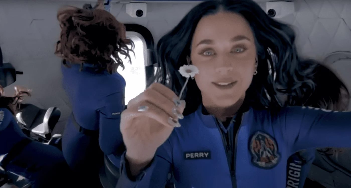 Katy Perry en gravedad cero dentro de la cápsula de Blue Origin, sosteniendo una flor mientras flota en el espacio junto a otras pasajeras