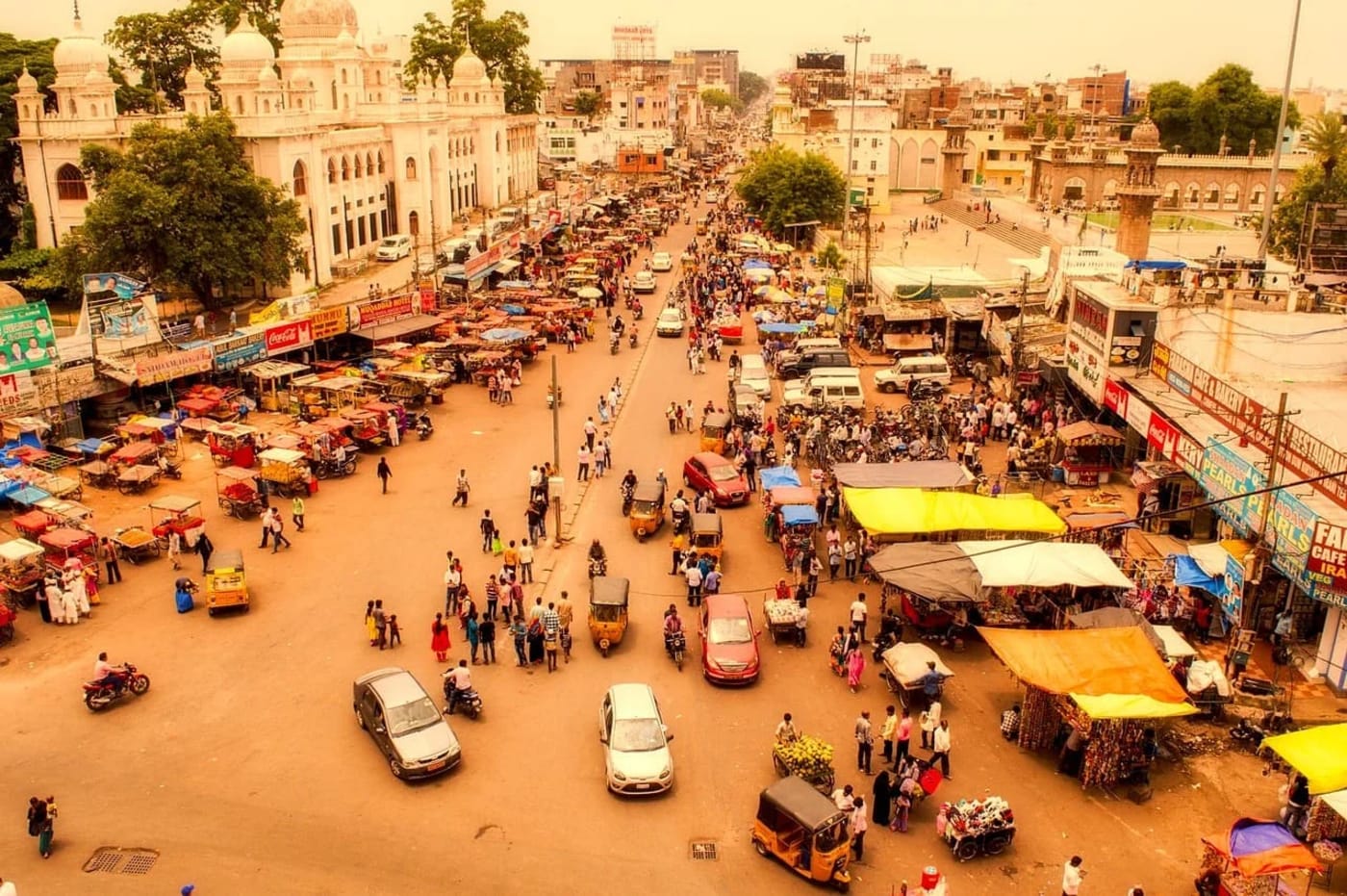 Multitud recorriendo un mercado urbano en Hyderabad, India, en una escena de alta densidad poblacional y vida cotidiana activa.
