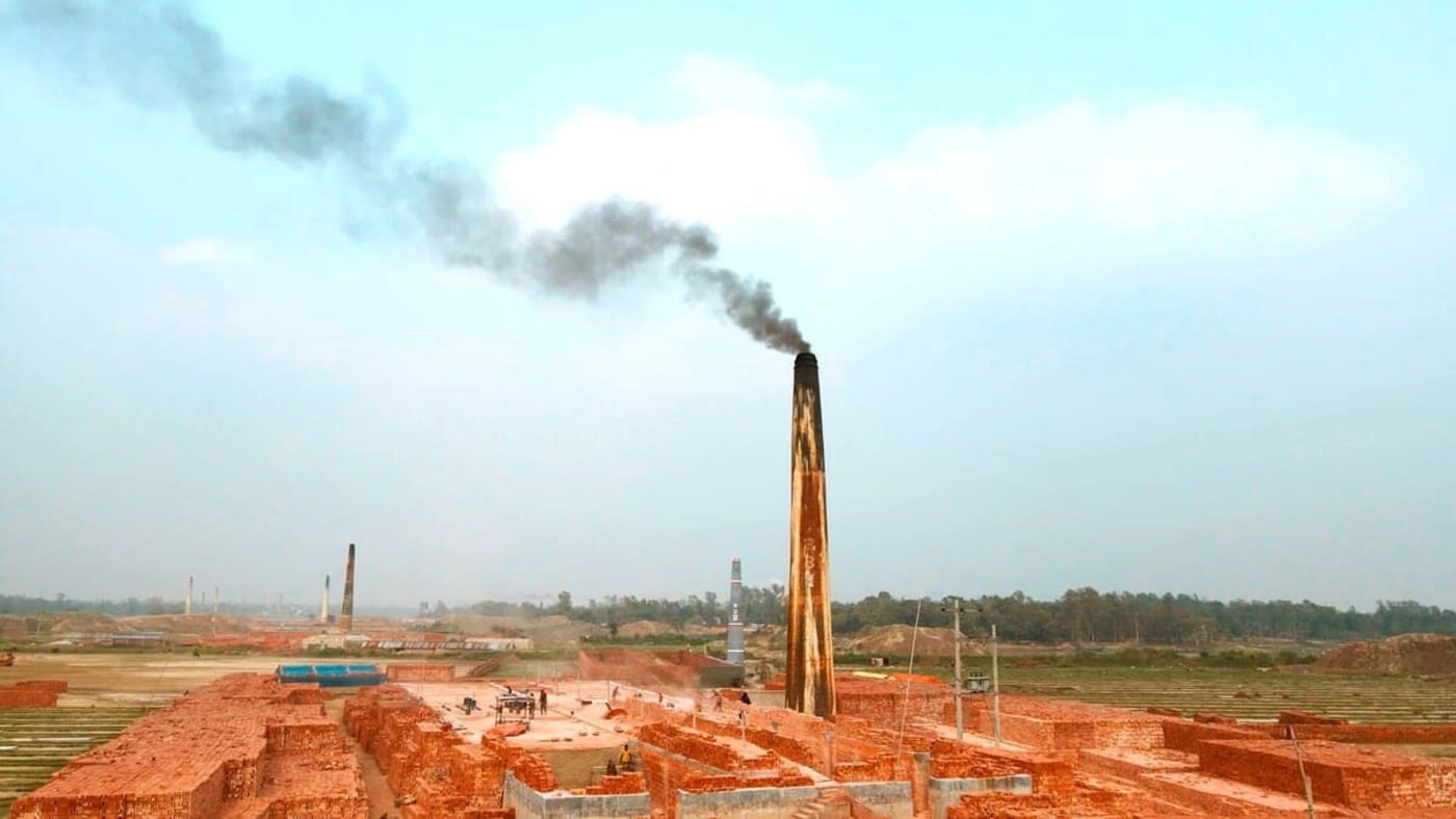 Vista aérea de una planta de hornos de ladrillos emitiendo humo en Bangladesh