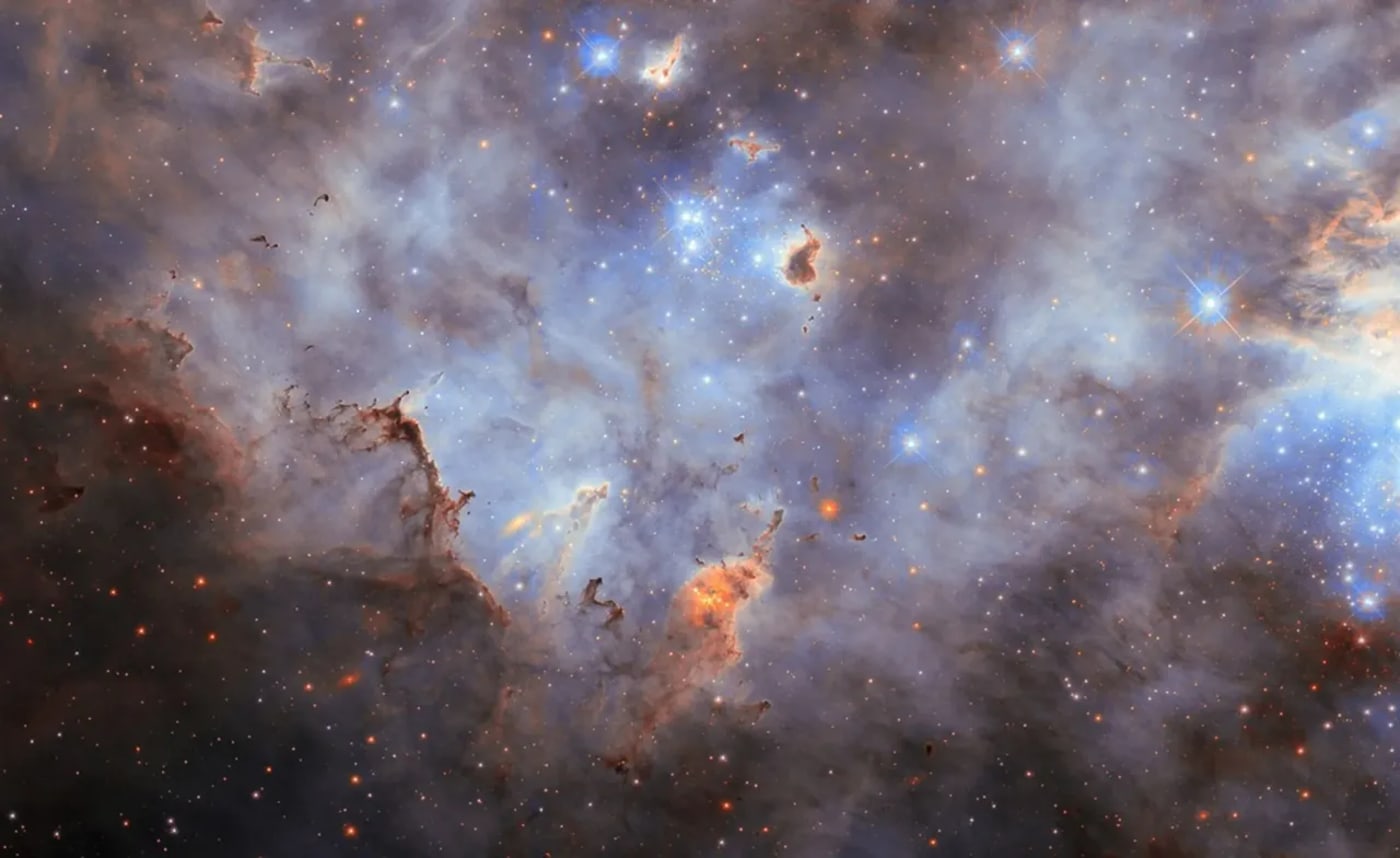 Cúmulo estelar en la Gran Nube de Magallanes con nubes de gas y polvo iluminadas por estrellas jóvenes