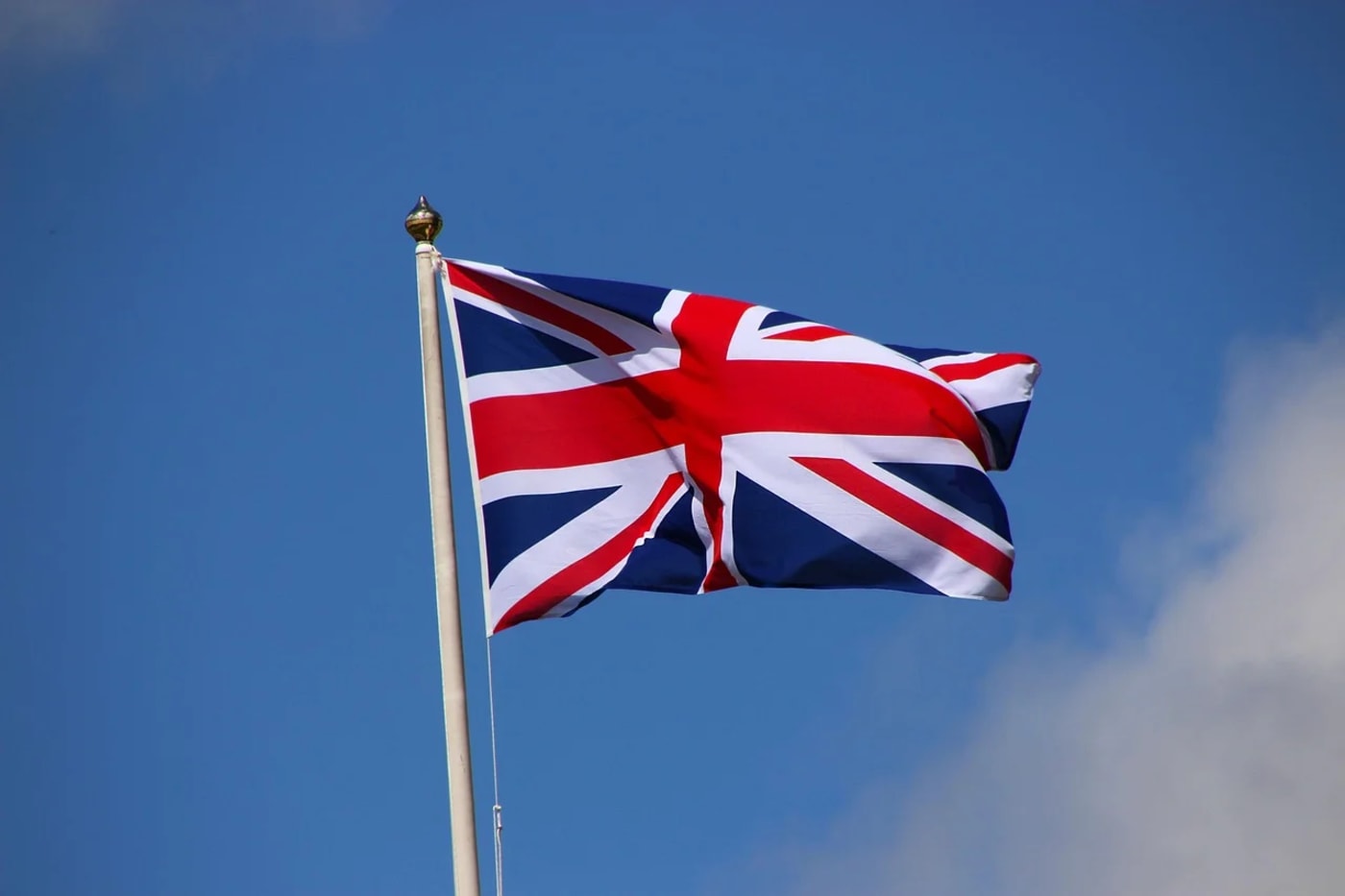 Bandera del Reino Unido ondeando bajo un cielo azul