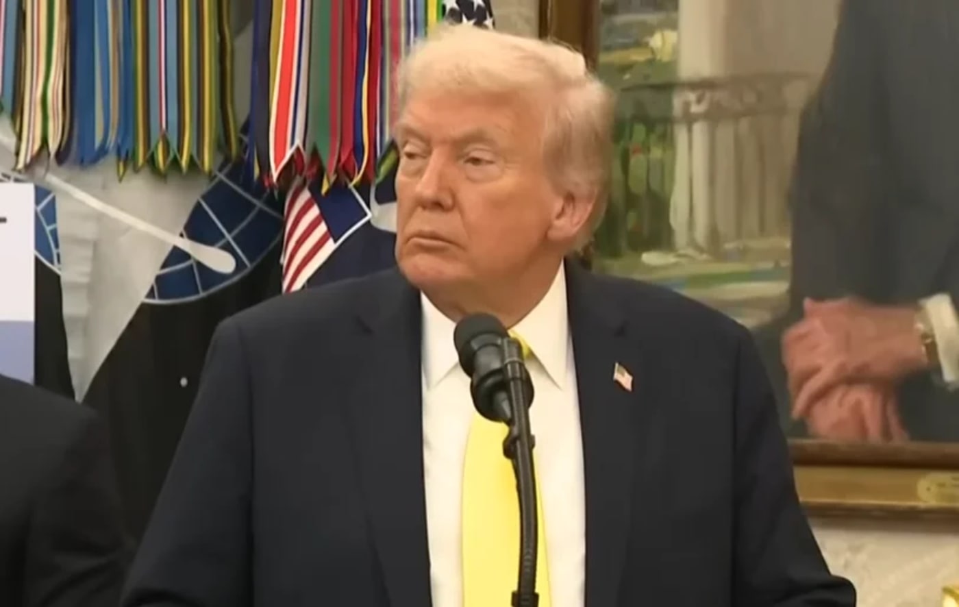 Donald Trump en una sala oficial, con banderas al fondo