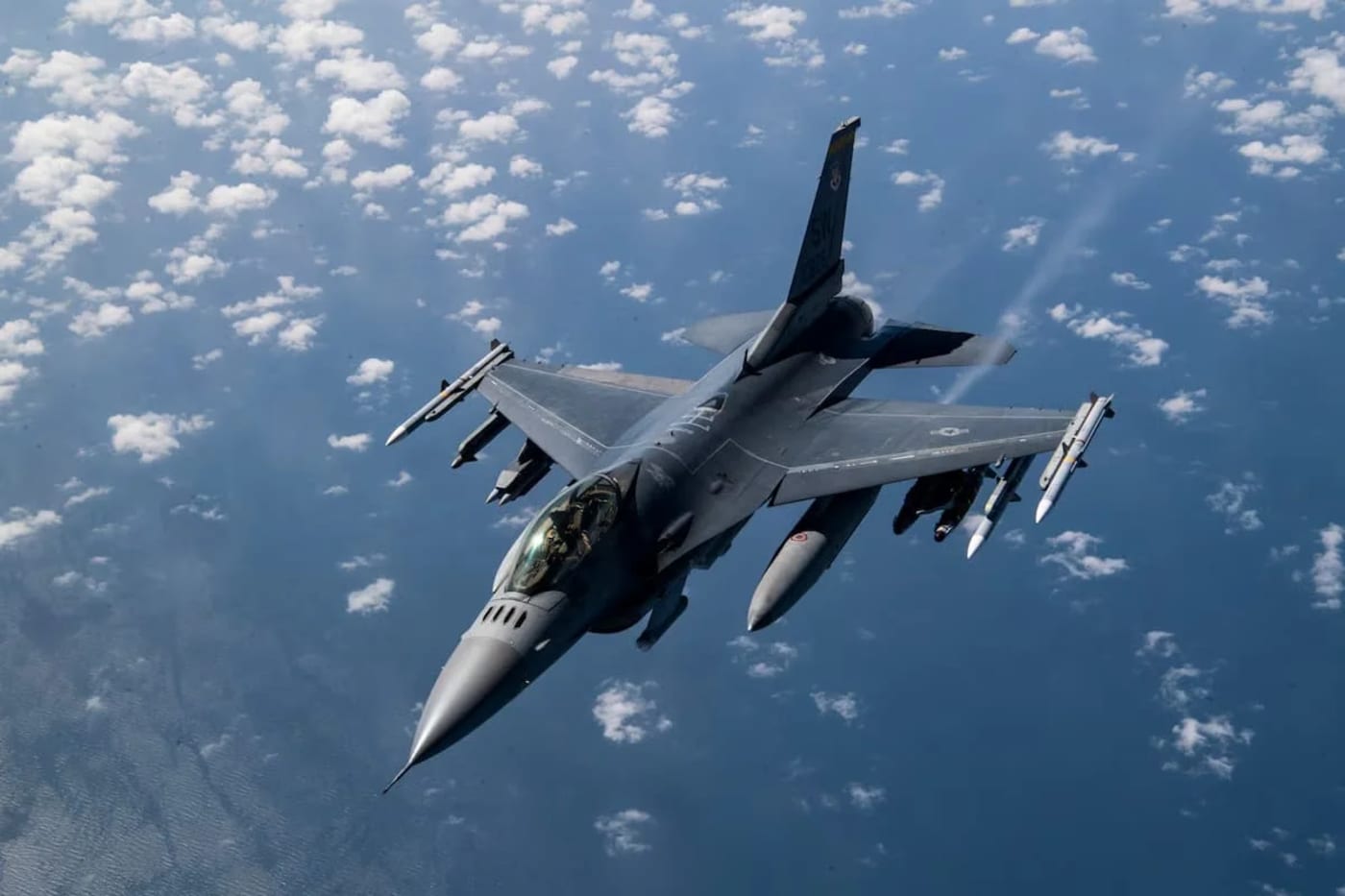 Técnicos inspeccionan el tren de aterrizaje de un F-16 Fighting Falcon en una base aérea