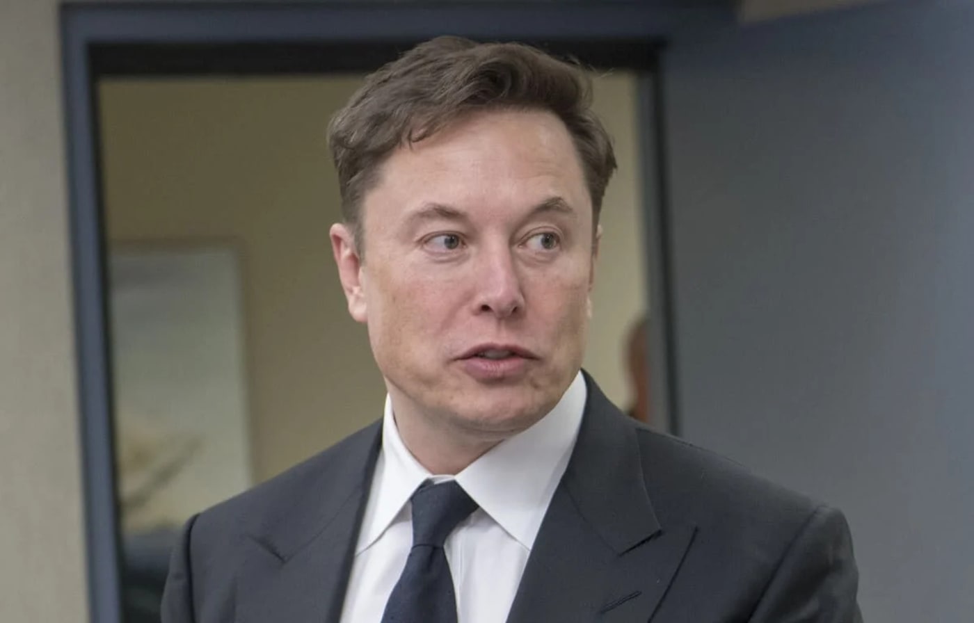 Elon Musk con traje oscuro y corbata azul