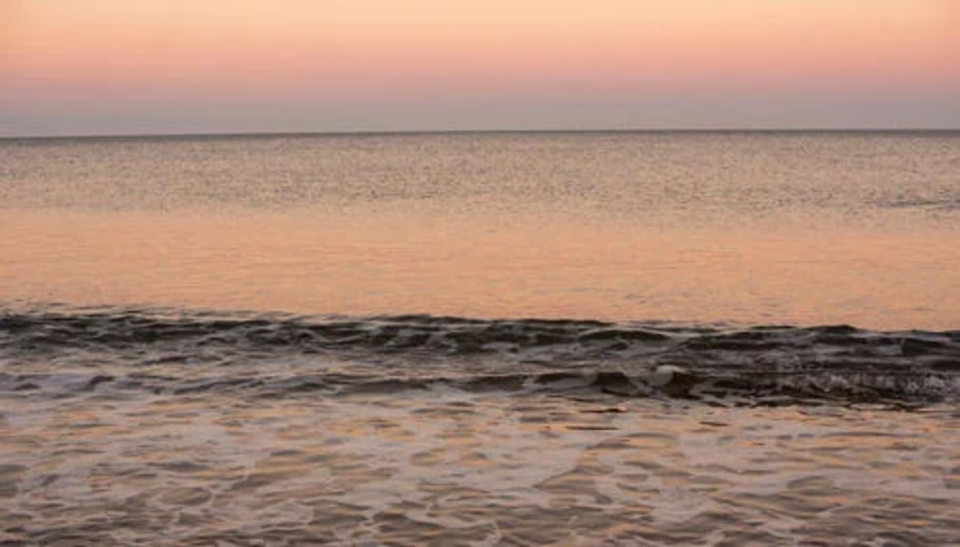 Olas rompiendo cerca de la costa con tonos azul oscuro y espuma blanca, representando la acidificación del océano