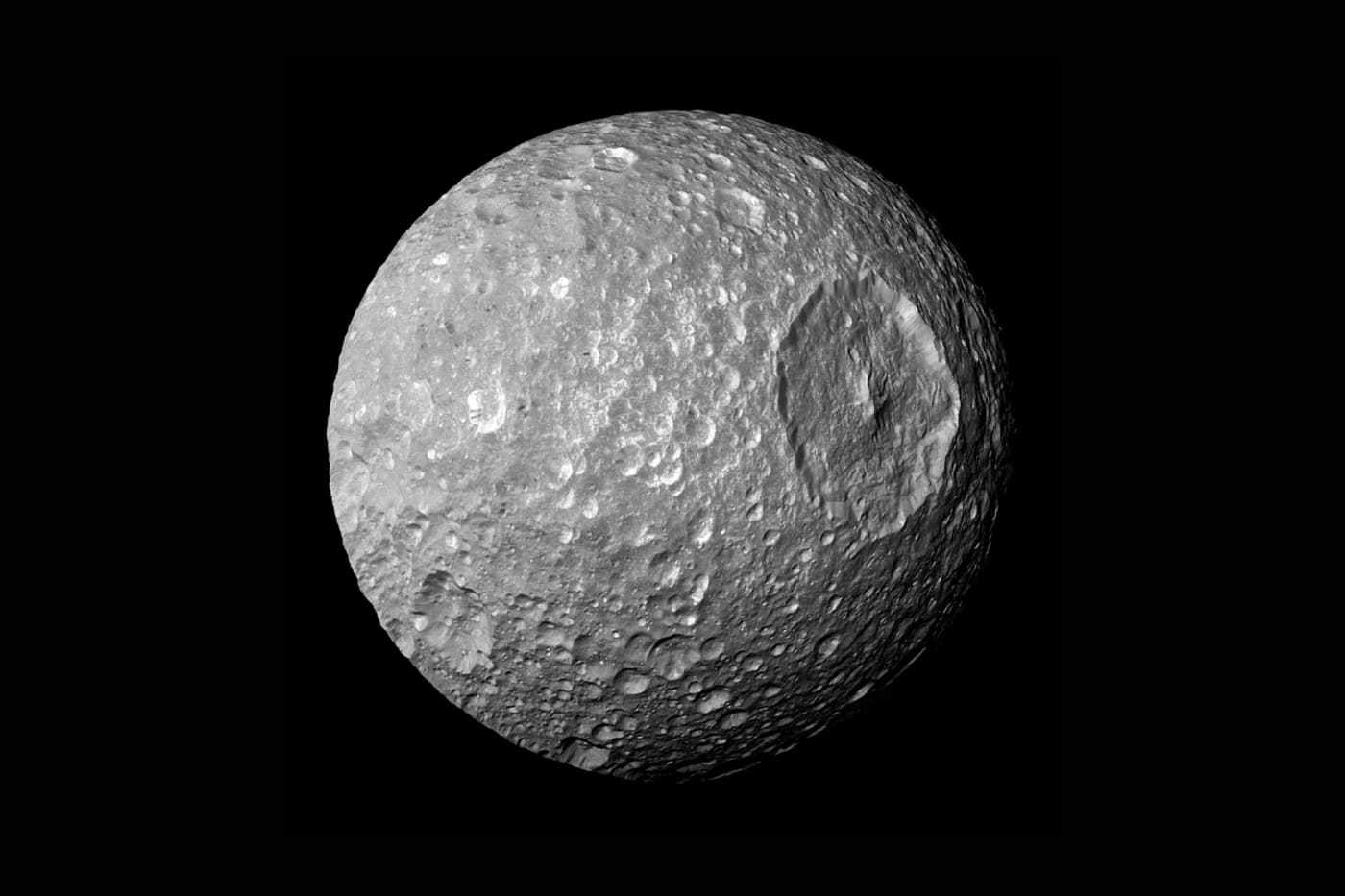 La luna Mimas de Saturno vista por la sonda Cassini, con detalles de su superficie helada