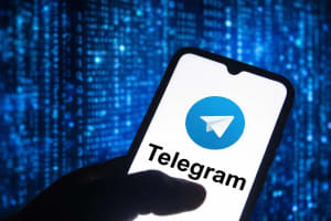 Teléfono con Telegram sobre fondo digital azul estilo ciberataque