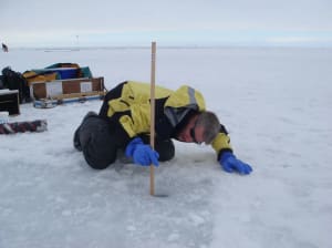 Investigador en la banquisa antártica realizando mediciones científicas