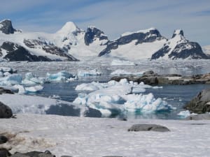 Paisaje helado de la Antártida con icebergs y montañas nevadas.